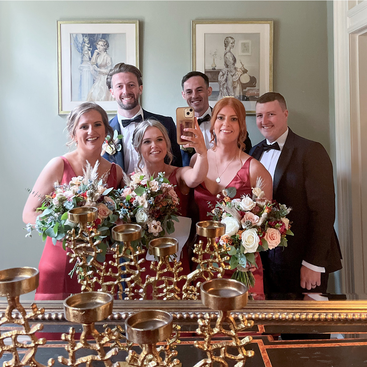 bridal party group selfie taken using a mirror at a wedding venue